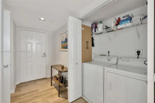 a storage room with a sink and wooden floor