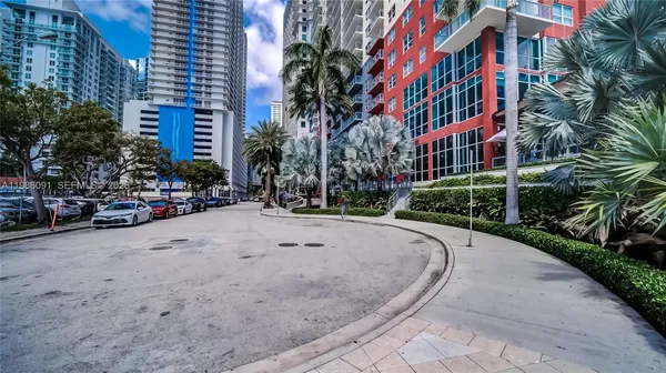 a row of palm trees sitting in front of a building