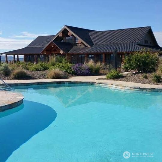 446 Plata Road Brewster, WA 98812 - Photo 26 of 32 a view of a house with swimming pool and a yard