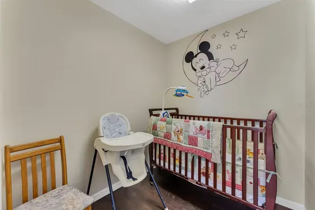 a bedroom with a large bed and a flat tv screen on dresser