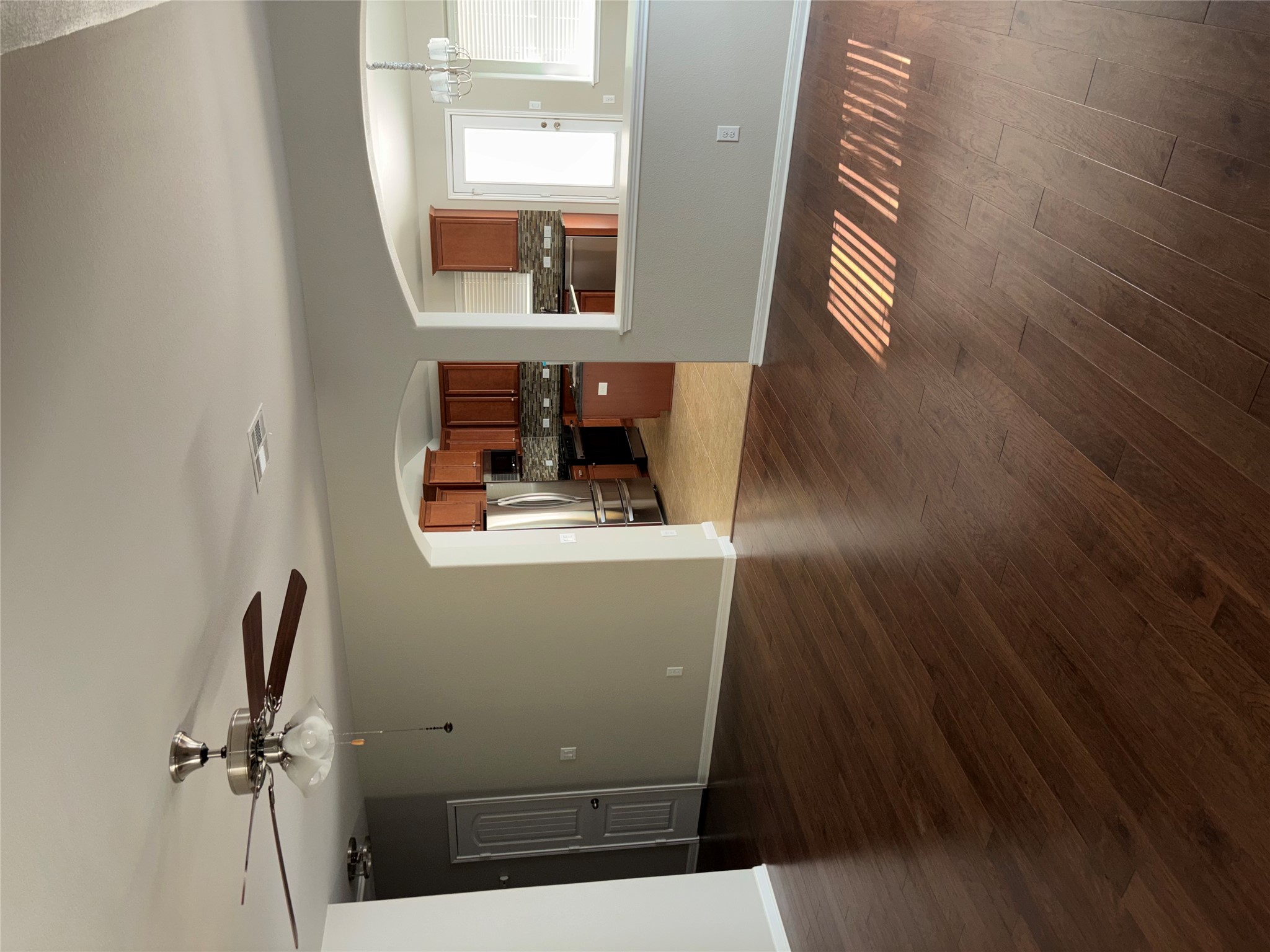 634 River Bluff Circle Georgetown, TX 78626 - Photo 6 of 37 Unfurnished living room with arched walkways, ceiling fan, dark wood-style flooring, and a chandelier