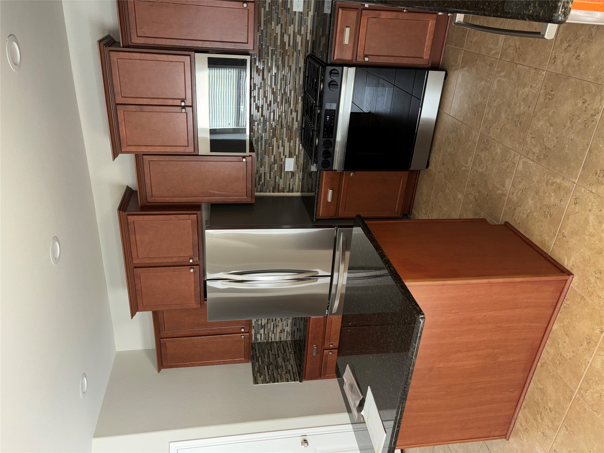 634 River Bluff Circle Georgetown, TX 78626 - Photo 10 of 37 Kitchen featuring stainless steel appliances, dark stone counters, tasteful backsplash, wood finish cabinetry, and recessed lighting