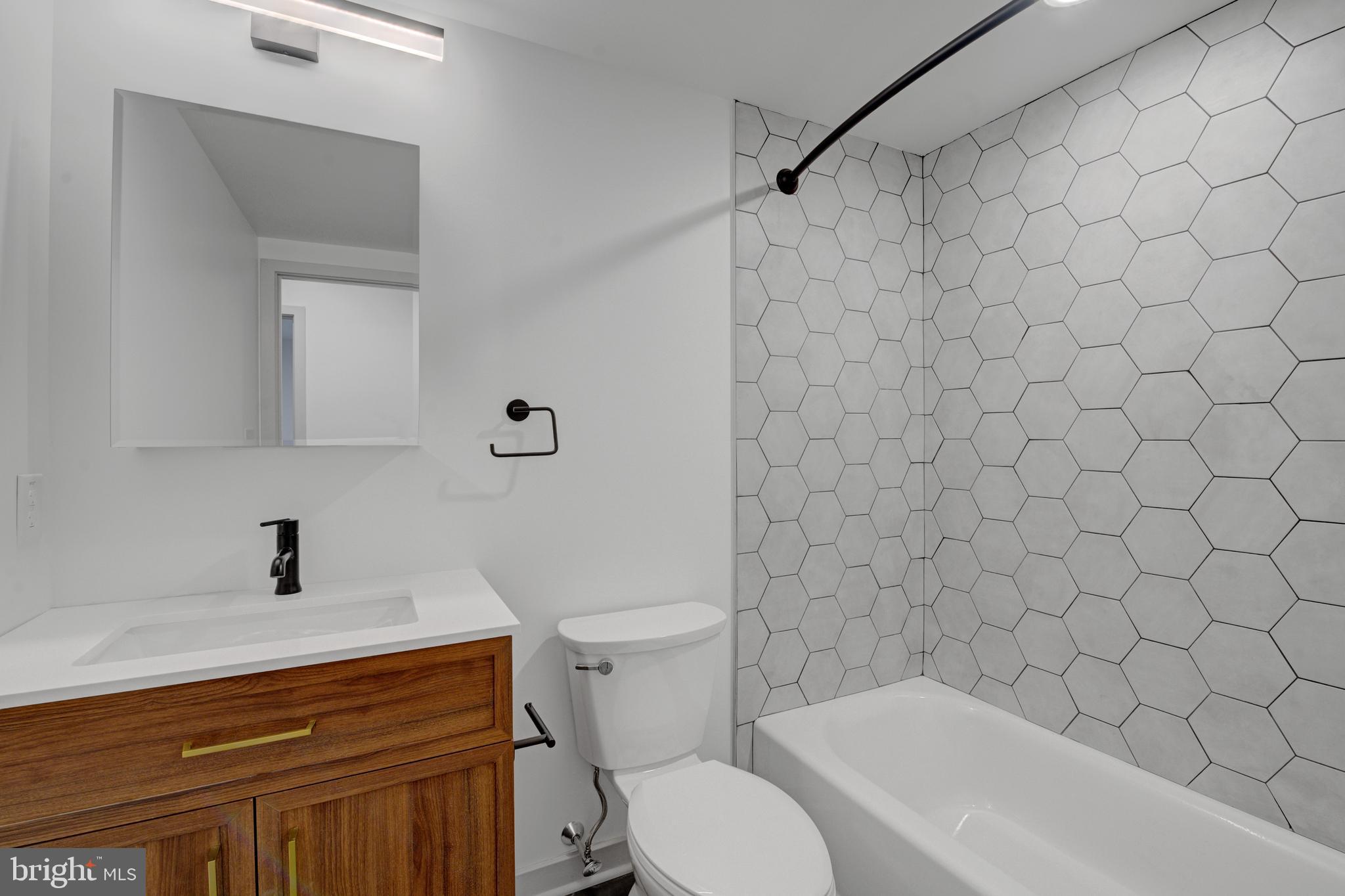 6808 Ridge Avenue, Unit 218 Philadelphia, PA 19128 - Photo 9 of 10 a bathroom with a sink a toilet and a mirror