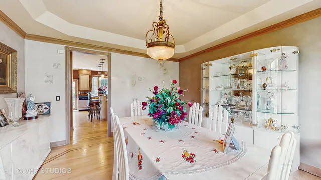 a dining room with furniture large windows and a chandelier