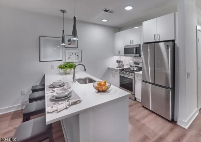 a kitchen with stainless steel appliances granite countertop a sink and a refrigerator