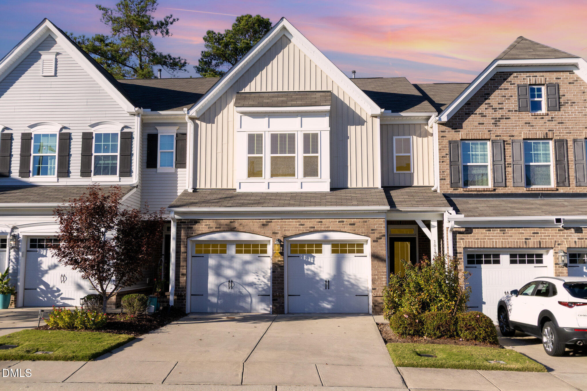 a view of a white house with large windows next to a road