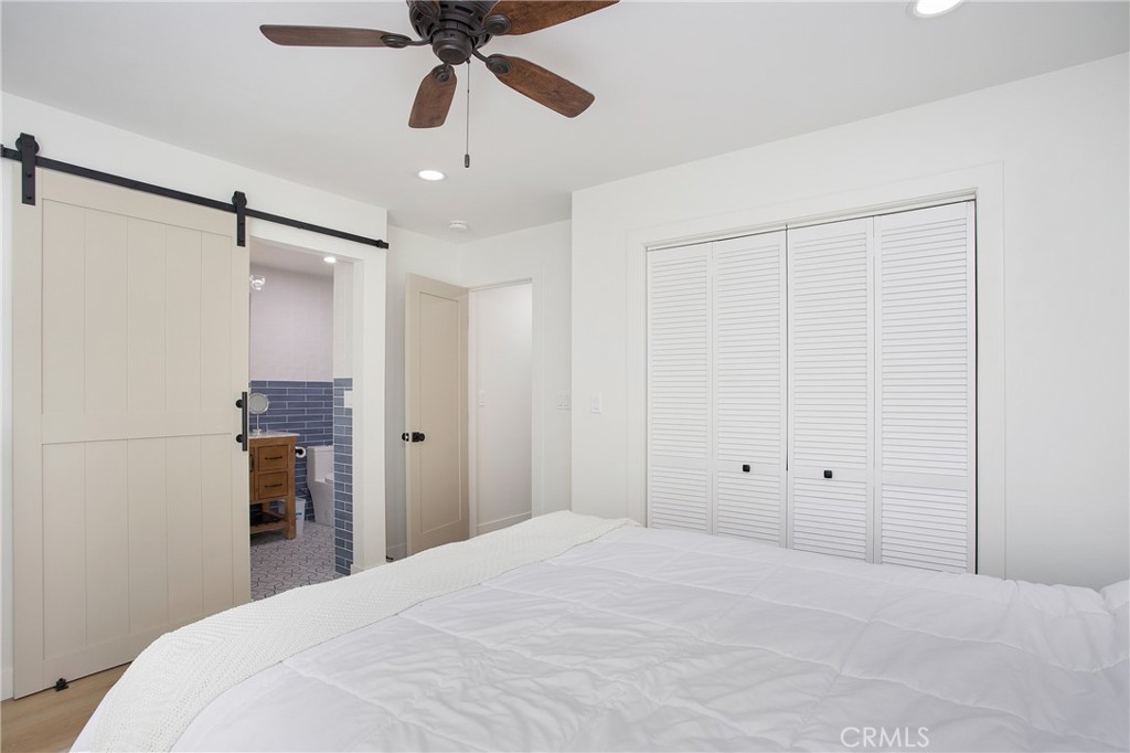 6265 Majorca Circle Long Beach, CA 90803 - Photo 22 of 38 a bedroom with a large bed and a chandelier fan