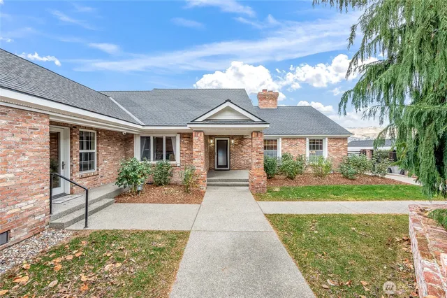 a front view of a house with a yard and potted plants