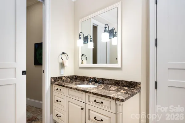 a bathroom with a granite countertop sink and a mirror