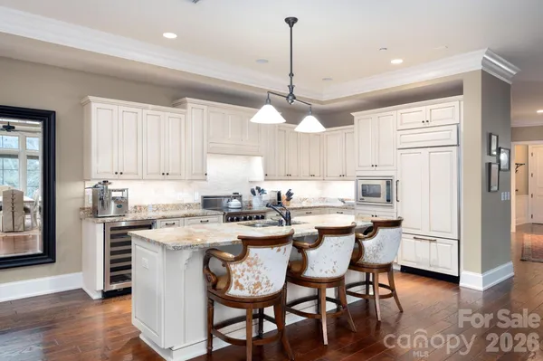 a kitchen with a dining table chairs stainless steel appliances and cabinets