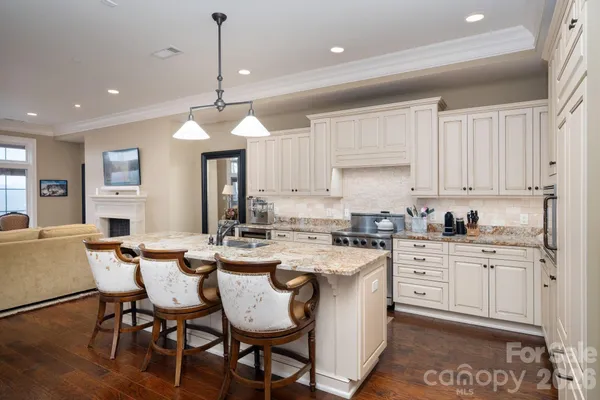 a kitchen with a dining table chairs sink and cabinets