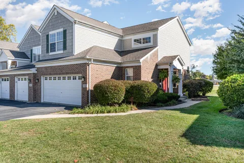 a view of a white house with a big yard and large windows