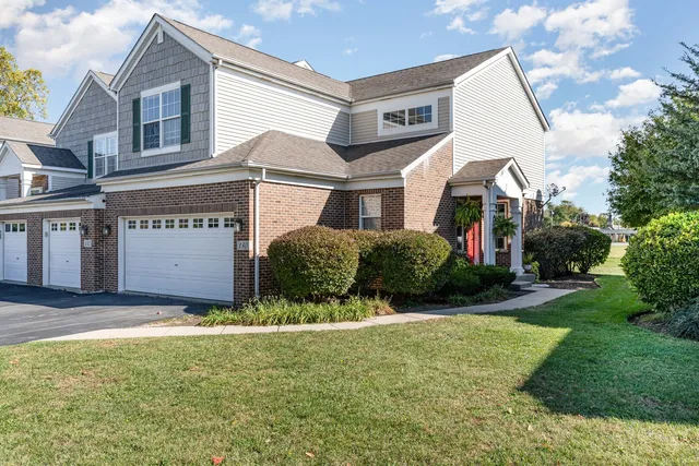 a view of a white house with a big yard and large windows