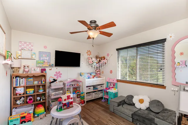 a living room with couches chairs and a potted plant