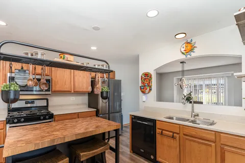 a kitchen with stainless steel appliances a stove a sink dishwasher and cabinets with wooden floor
