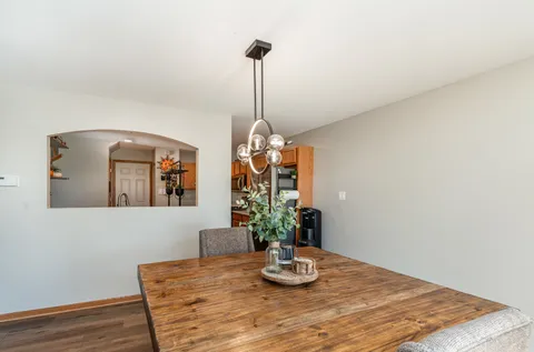 a dining room with table chairs and wooden floor
