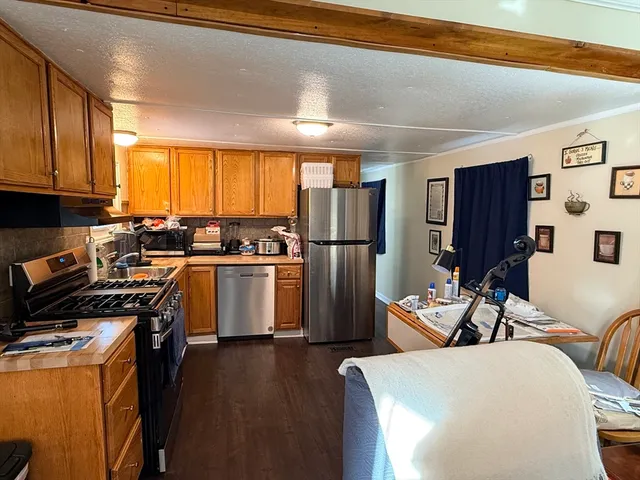 a kitchen with stainless steel appliances a refrigerator a sink a stove and cabinets