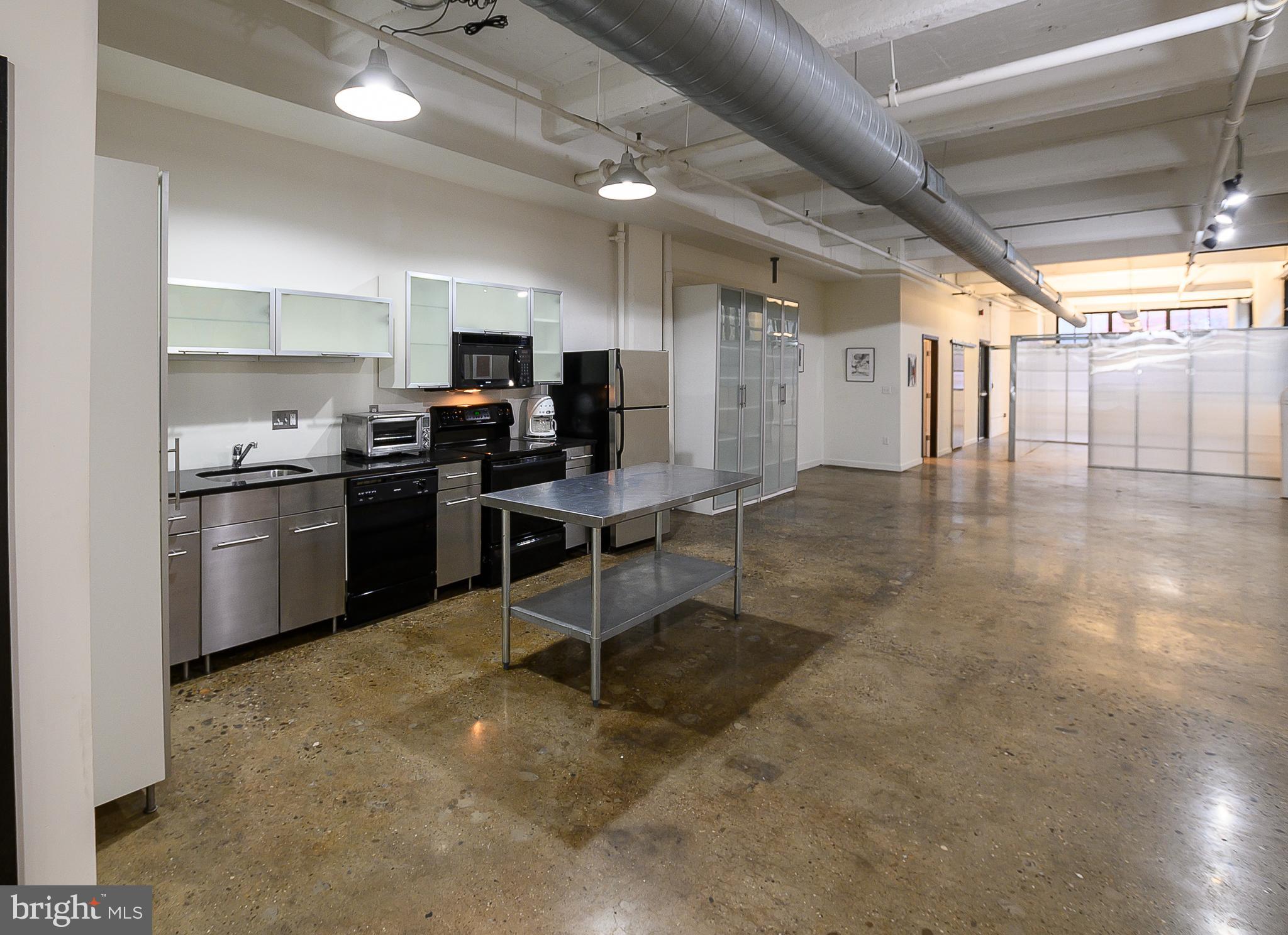 20 North 3rd Street, Unit 302 Philadelphia, PA 19106 - Photo 12 of 24 a view of a kitchen with kitchen island a counter top space a sink stainless steel appliances and cabinets