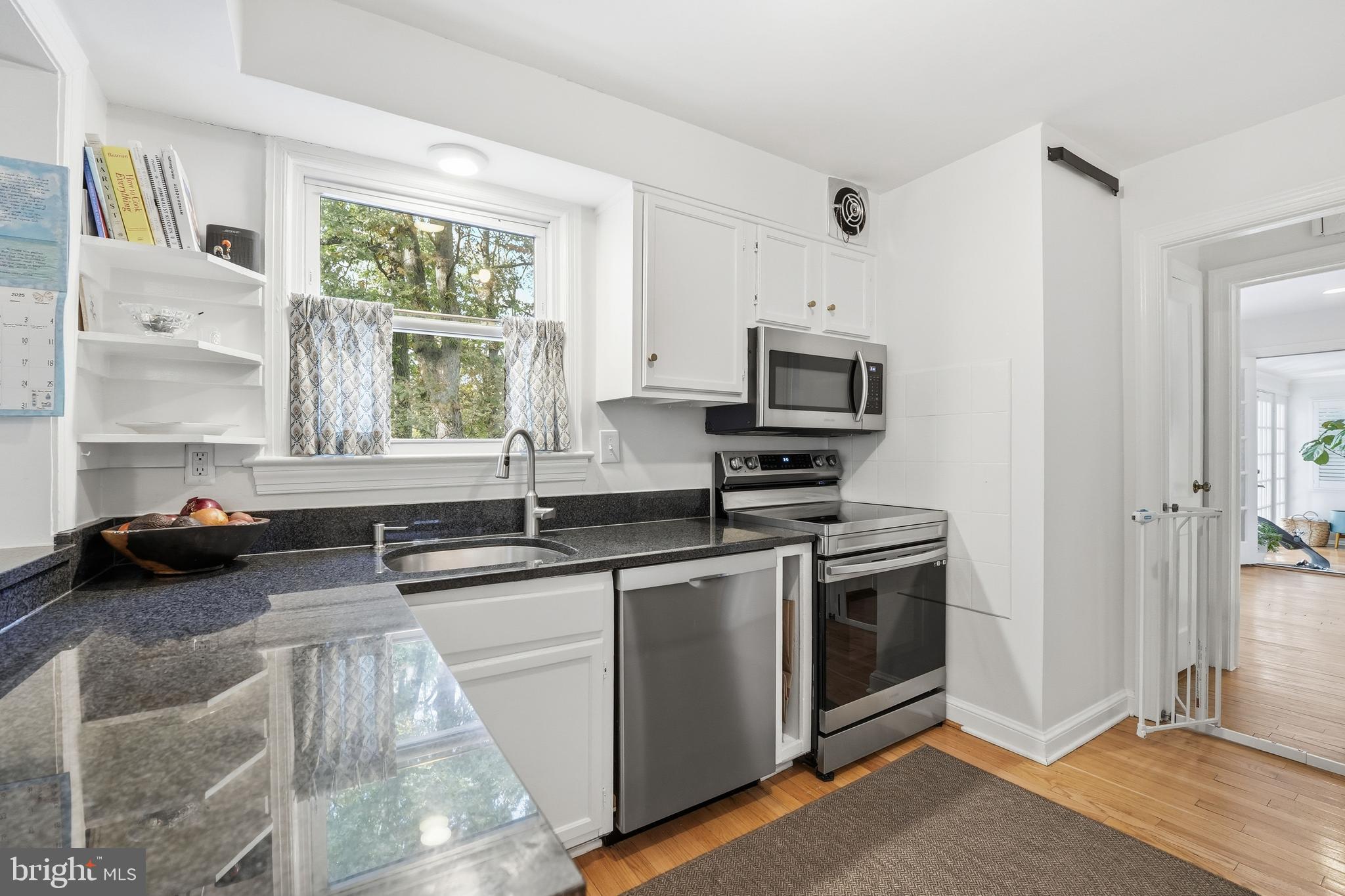 6032 Grove Drive Alexandria, VA 22307 - Photo 9 of 40 a kitchen with a stove a sink and a microwave