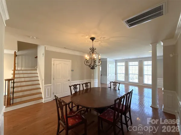 an empty room with windows and chandelier fan