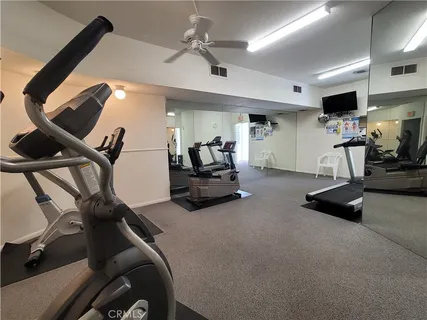 a room with gym equipment and a flat screen tv