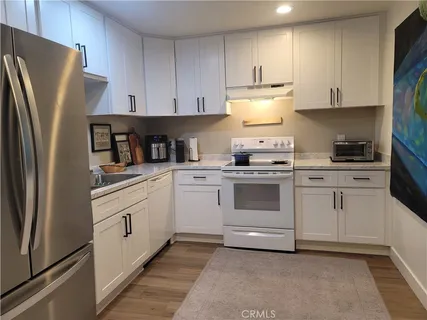 a kitchen with white cabinets and stainless steel appliances