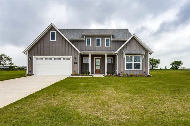 a front view of a house with a garden and yard