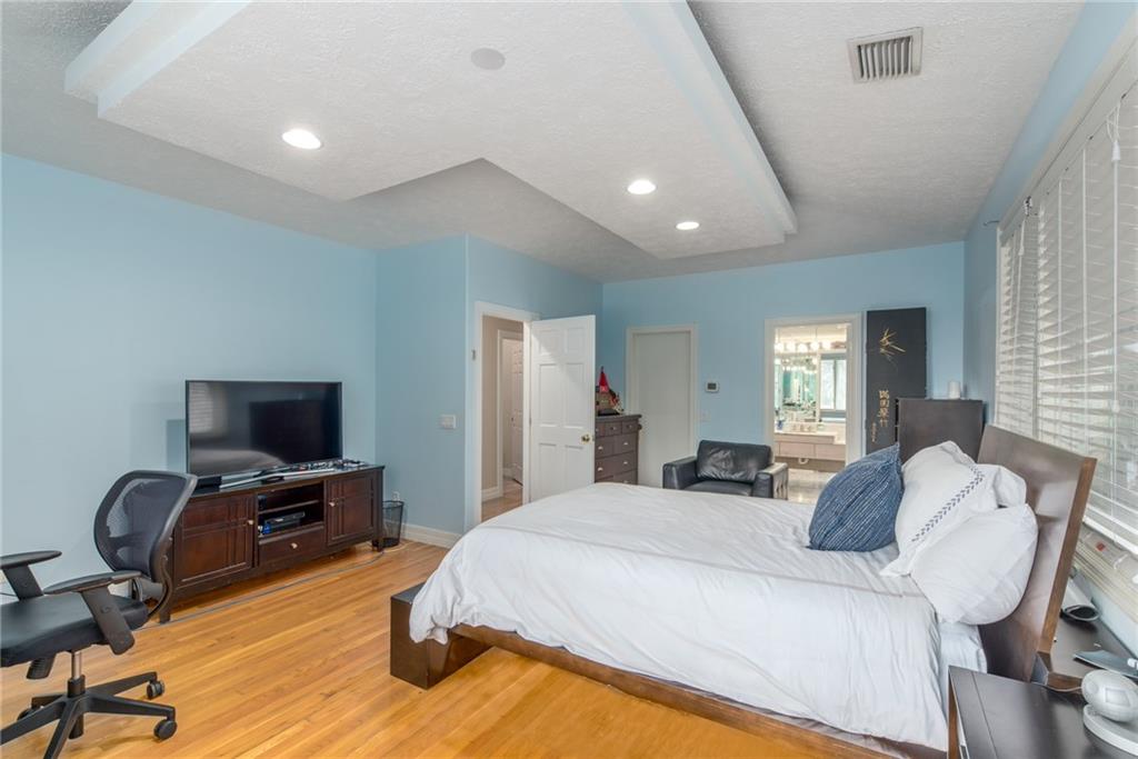 137 South River Road Stuart, FL 34996 - Photo 26 of 55 a bedroom with a bed a chair and a flat screen tv