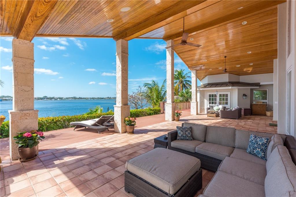 137 South River Road Stuart, FL 34996 - Photo 40 of 55 a view of a patio with couches and chairs under an umbrella