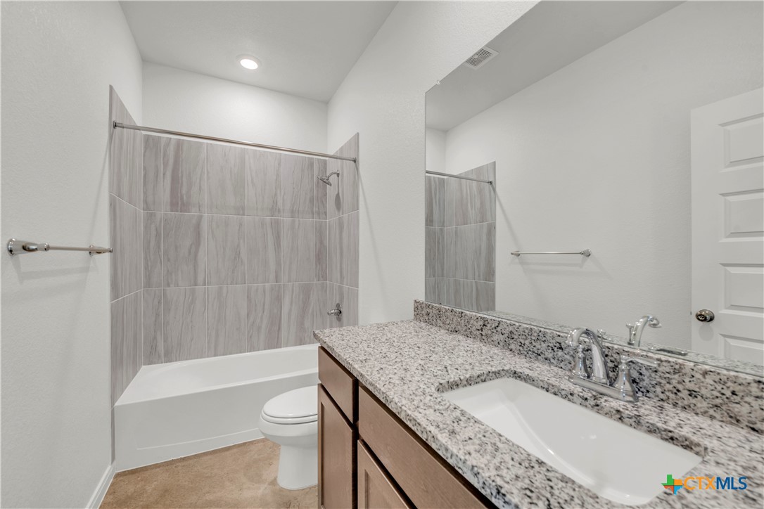 3901 Sugar Hackberry Trail Killeen, TX 76542 - Photo 13 of 16 a bathroom with a granite countertop sink toilet and shower