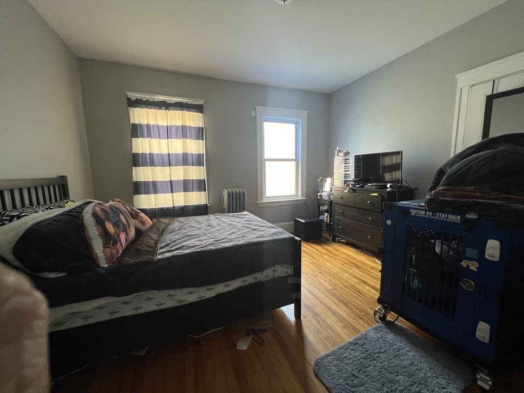 39 Woodford Street, Unit 2 Worcester, MA 01604 - Photo 15 of 20 a bed sitting in a bedroom next to a window with tv