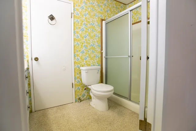 a bathroom with a toilet and a shower