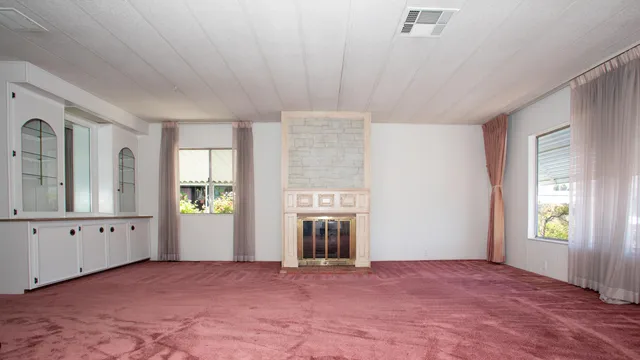 a view of an empty room with window and cabinet window