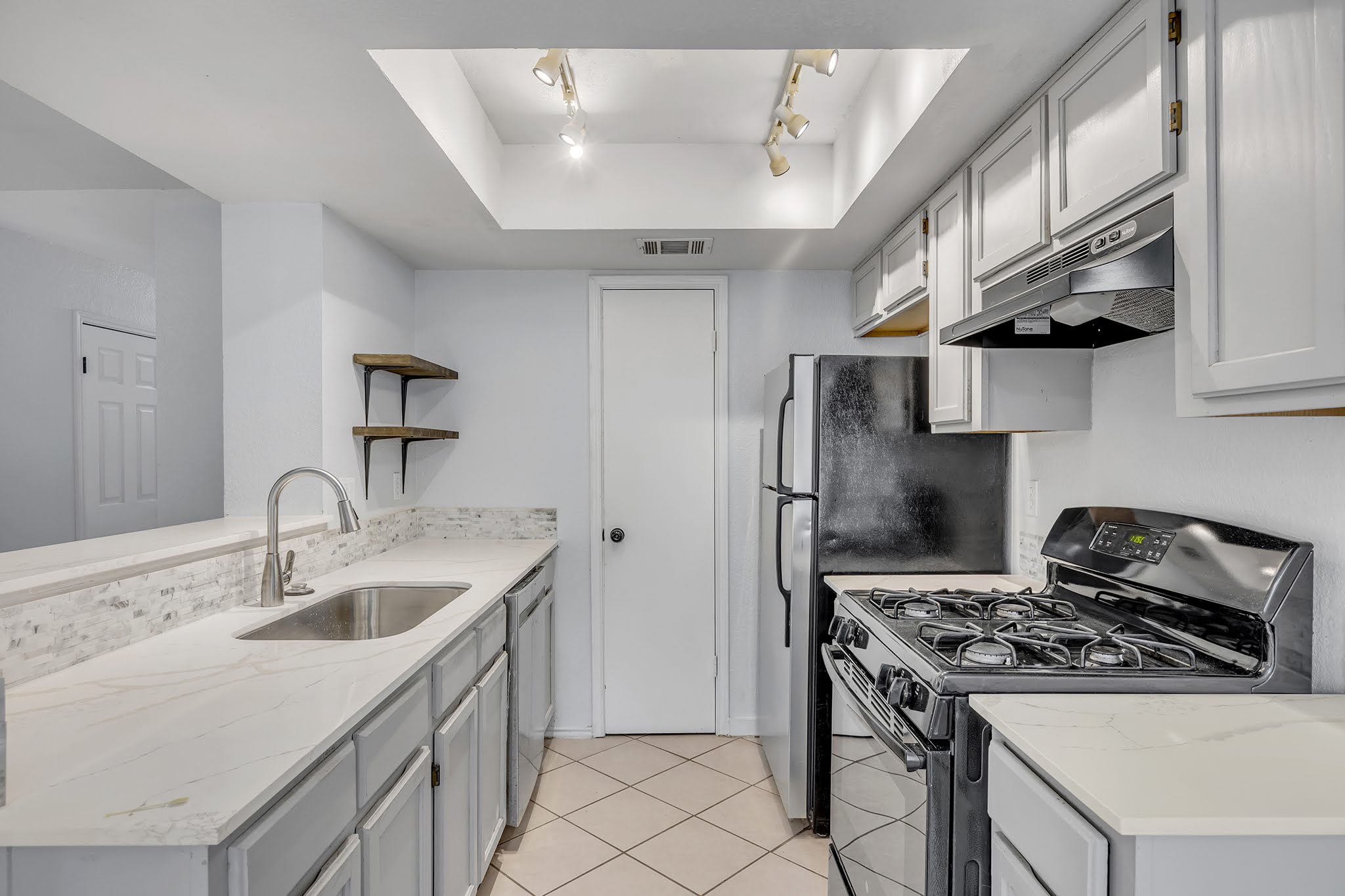 8102 Tuscarora Trail, Unit A Austin, TX 78729 - Photo 13 of 35 a kitchen with stainless steel appliances granite countertop a sink stove refrigerator and cabinets