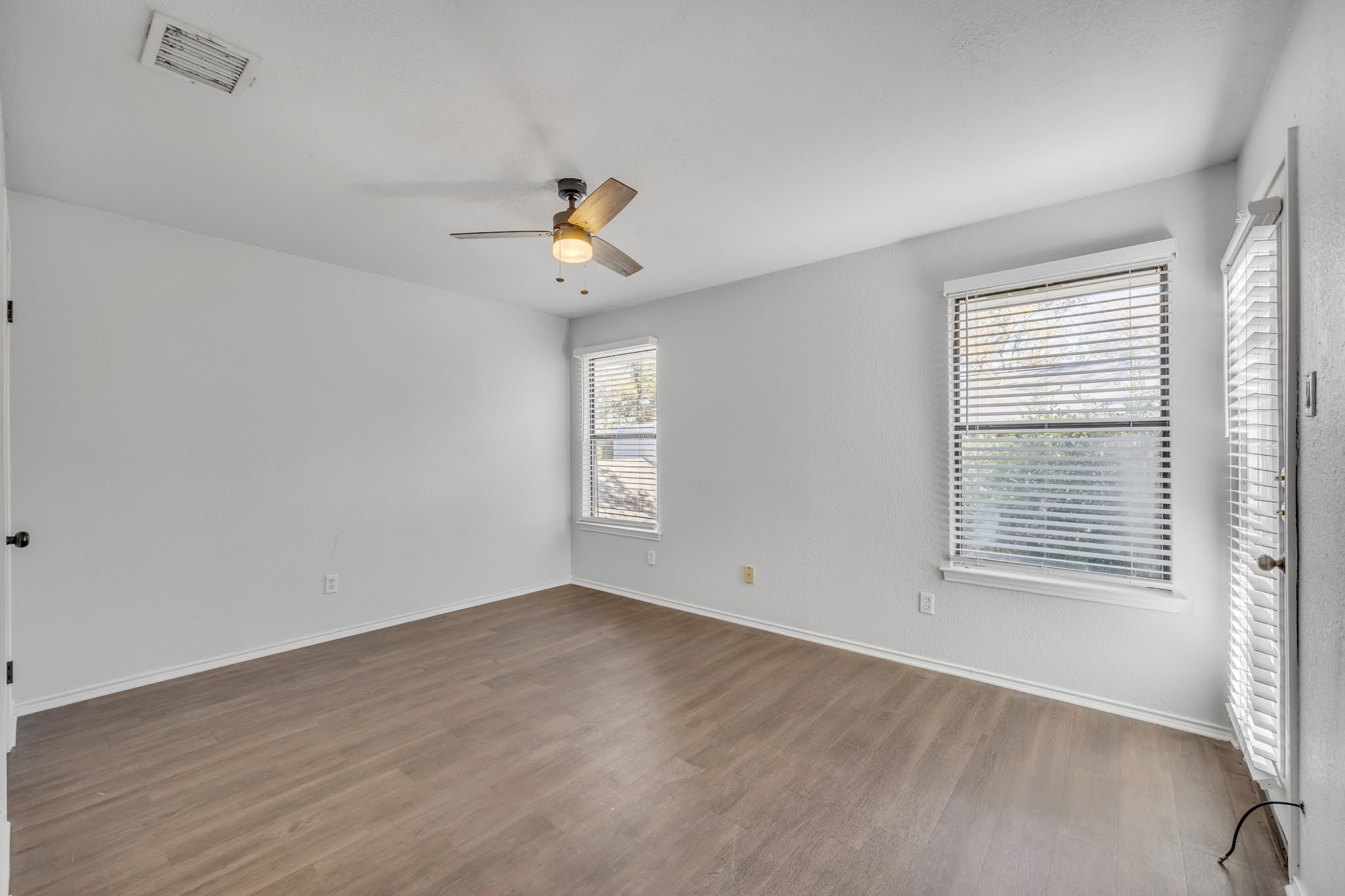 8102 Tuscarora Trail, Unit A Austin, TX 78729 - Photo 30 of 35 a view of an empty room with a window and wooden floor