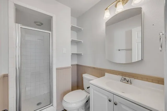 a bathroom with a sink a toilet and shower