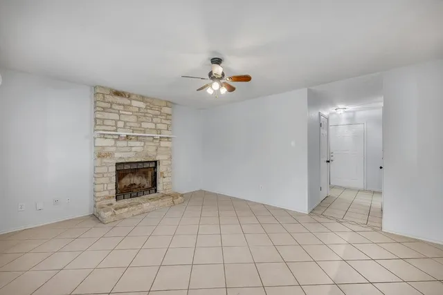 an empty room with windows and fireplace