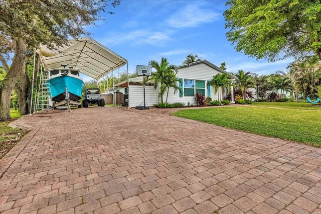 a view of a house with a yard and potted plants