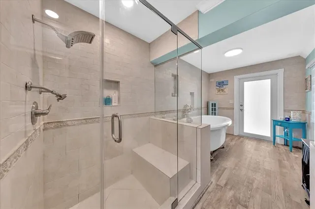 a bathroom with a tub shower sink and mirror