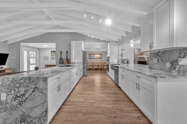 a large kitchen with stainless steel appliances lots of counter space and windows