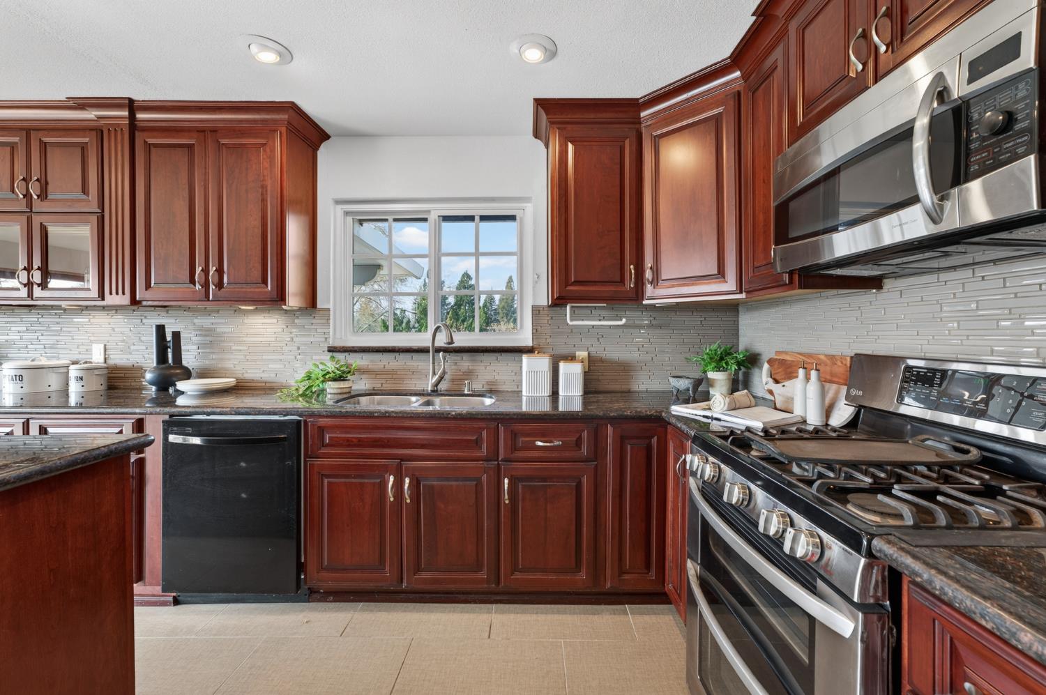 3006 Scenic Heights Way Carmichael, CA 95608 - Photo 19 of 76 a kitchen with stainless steel appliances granite countertop a stove a sink dishwasher and cabinets with wooden floor