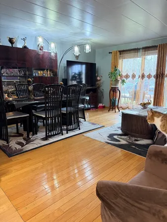 a living room with furniture a flat screen tv and kitchen view