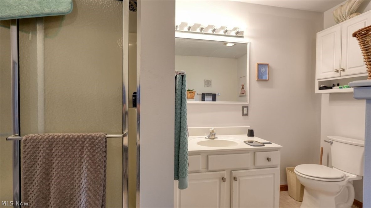 63155 Arrowhead Road Cambridge, OH 43725 - Photo 25 of 50 Bathroom with a shower with door, toilet, tile flooring, and vanity