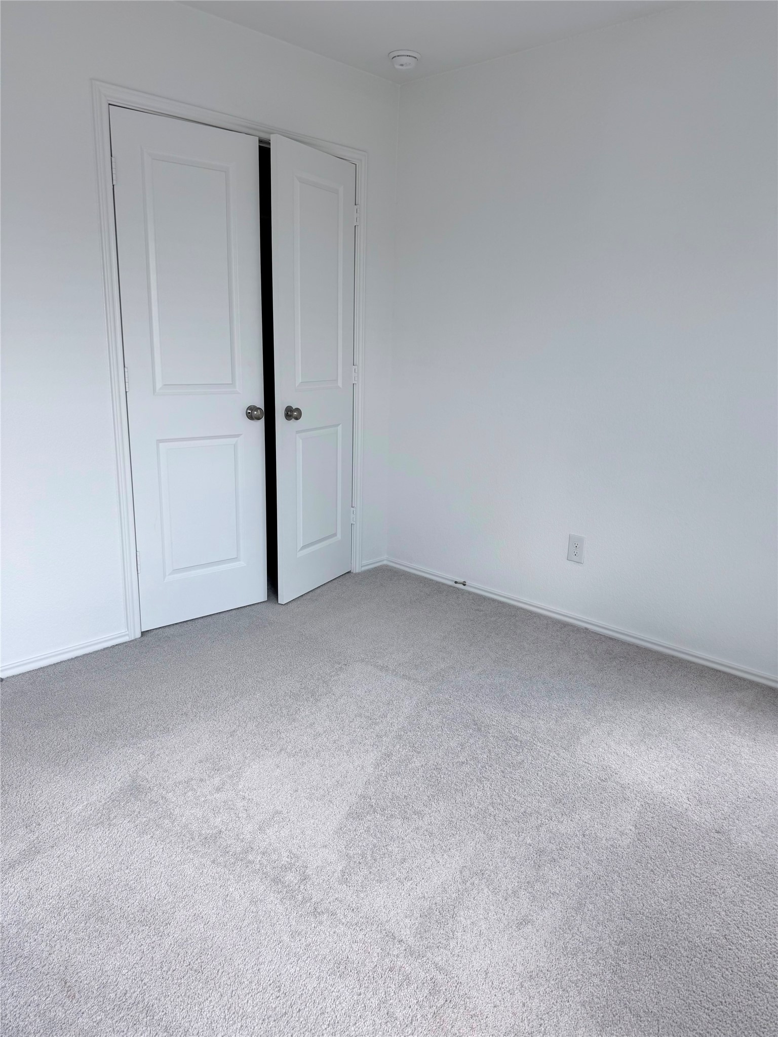 192 Rodney Boat Road Kyle, TX 78640 - Photo 36 of 40 A well-maintained carpeted room offers closet access behind classic double doors.
