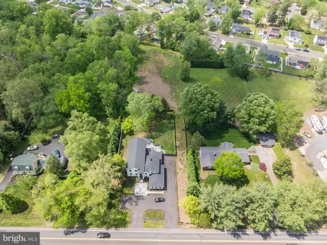 an aerial view of residential houses with outdoor space and trees