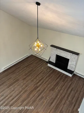 a view of a room that has a wooden floor and a fireplace