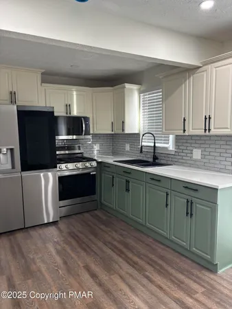 a kitchen with granite countertop a sink and steel appliances
