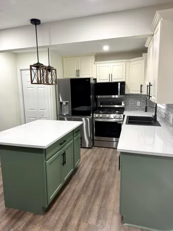 a kitchen with stainless steel appliances kitchen island a refrigerator sink and microwave