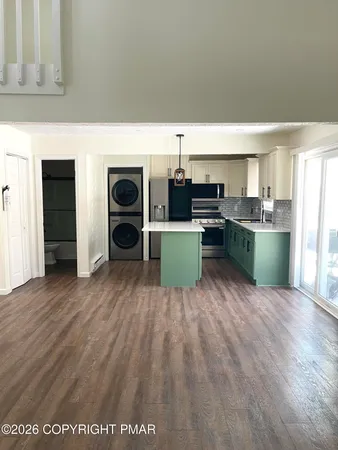 a living room with stainless steel appliances furniture and a fireplace