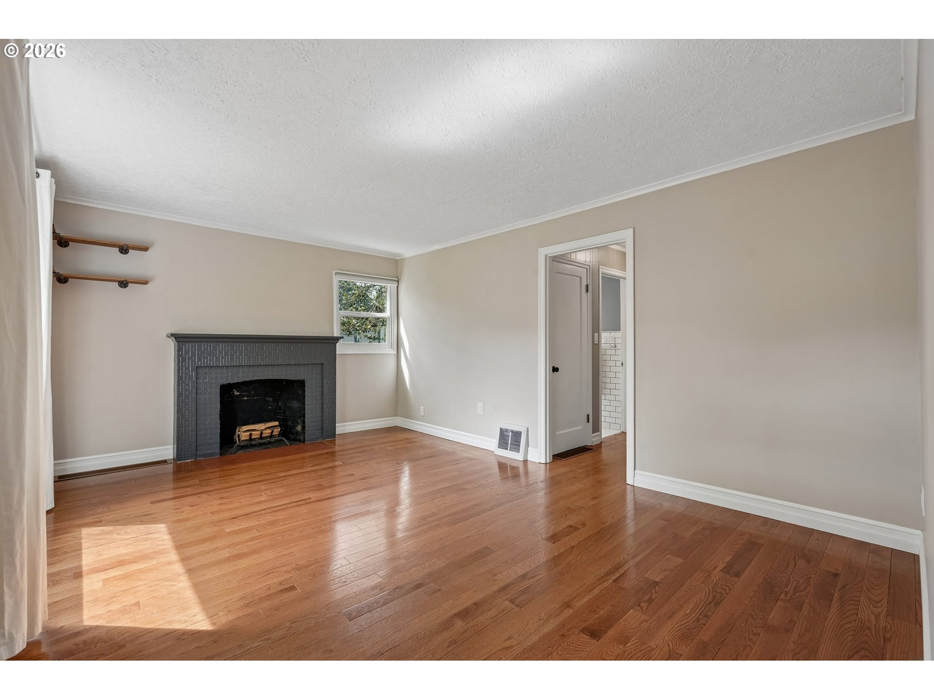 4204 Fir Street Vancouver, WA 98660 - Photo 5 of 37 a view of an empty room with wooden floor fireplace and a window